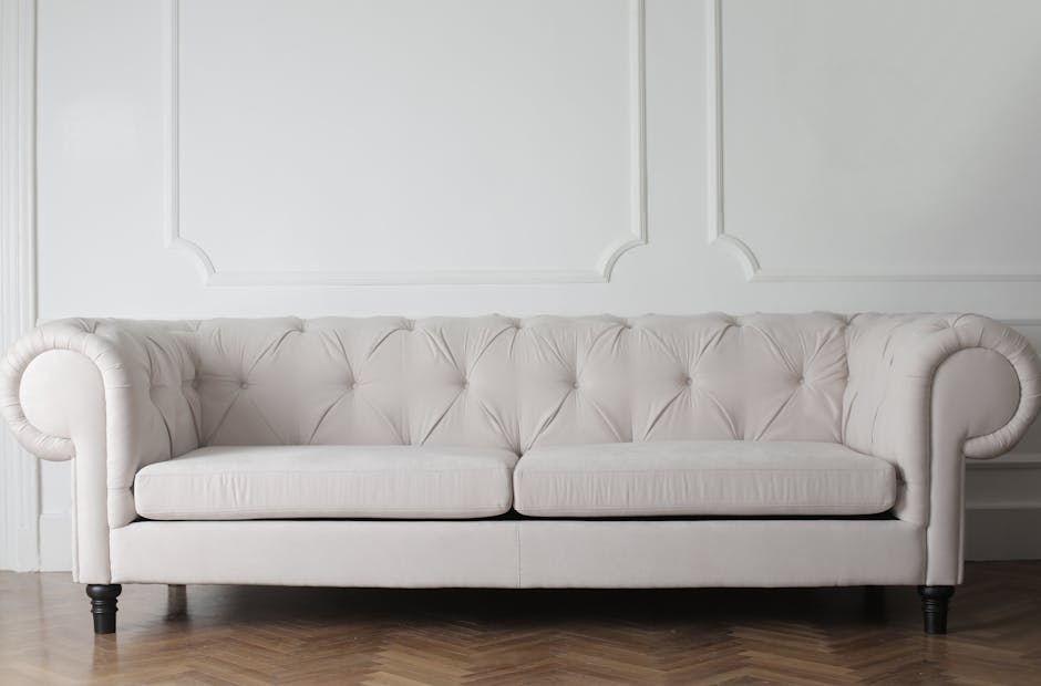 Luxurious white sofa in a modern minimalist interior with wooden flooring.