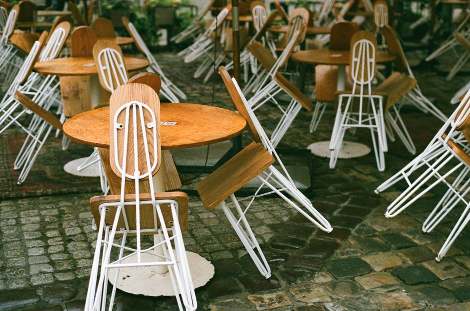 A scenic view of empty wooden tables and chairs in a cobblestone cafe setting in Lviv.