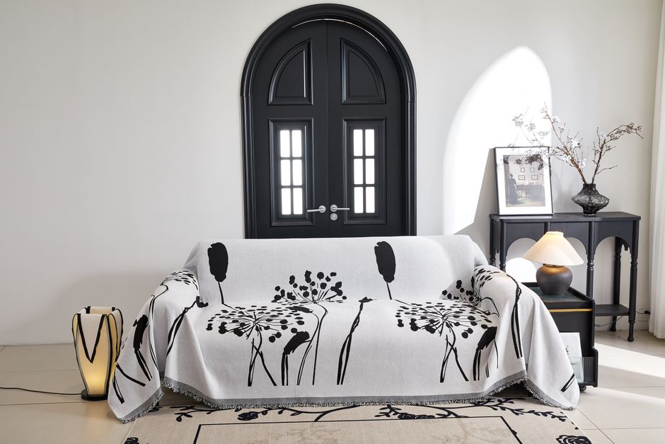 Black and white themed living room with a stylish floral sofa cover and elegant decor.