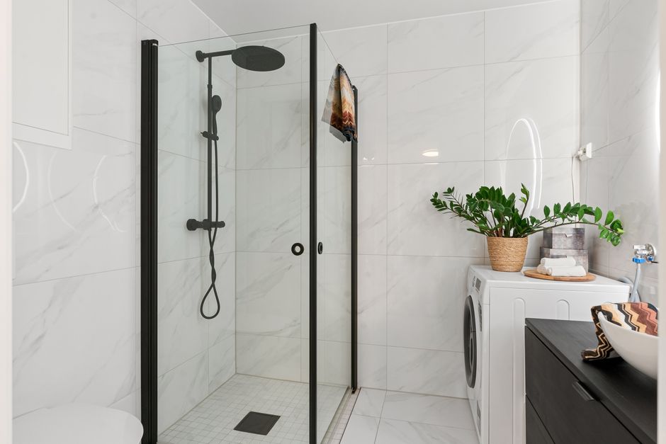 Bright and contemporary bathroom featuring a shower and laundry area in a minimalist design.