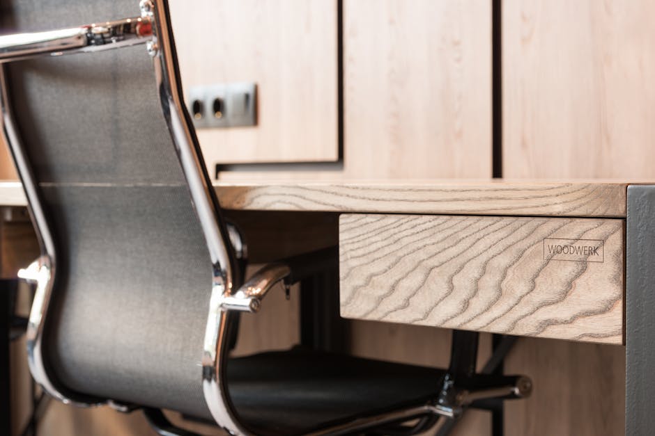 Creative design of wooden table with wavy lines and armchair against wall in contemporary workspace