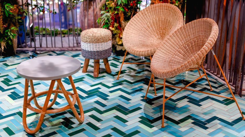 Elegant rattan furniture set on colorful chevron tile flooring in a Thai resort setting.