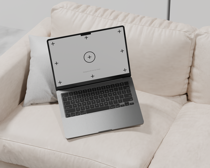 Sleek laptop placed on a cream sofa, suitable for tech and lifestyle themes.