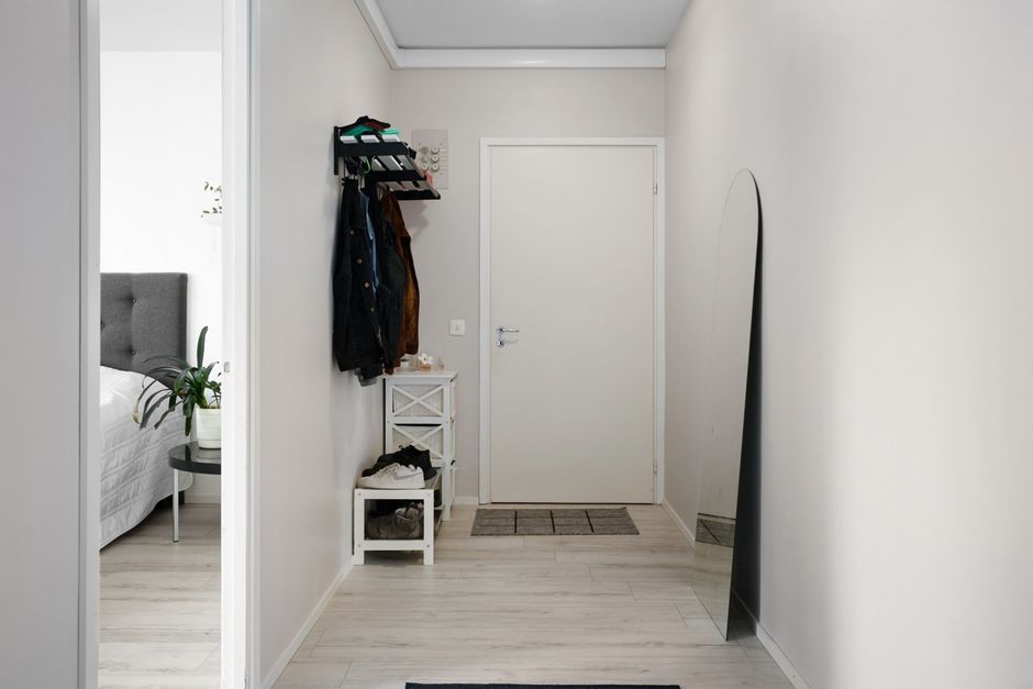 A minimalist hallway with white walls, modern decor, and simple furnishings.
