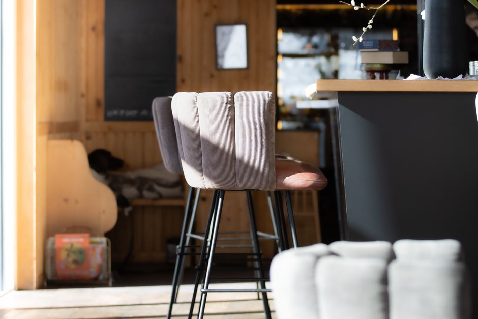 Bright and cozy cafe interior featuring modern bar stools and wooden decor.