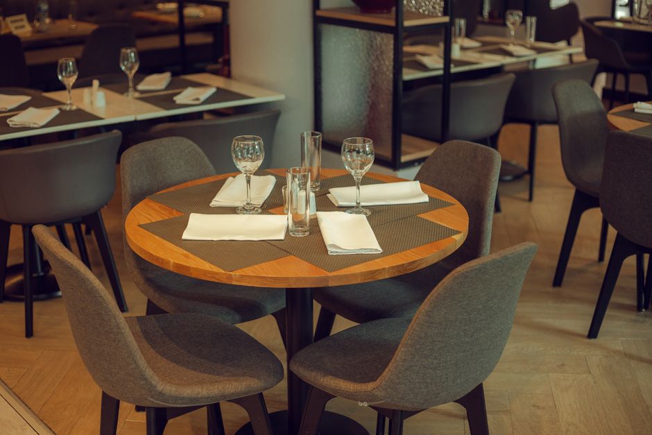 Chic restaurant table with modern decor, glassware, and cutlery, ready for guests.