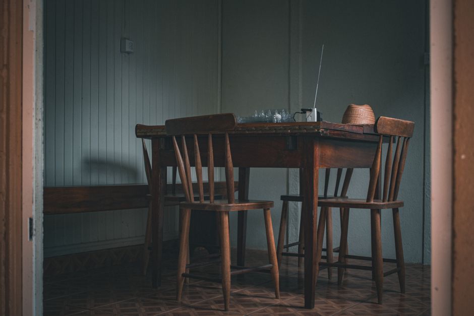 Cozy indoor scene featuring a wooden table and chairs, with a vintage radio.