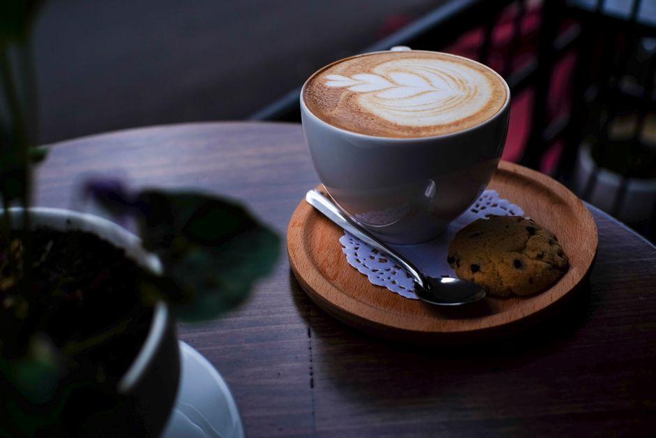 Elegant cappuccino with latte art served with a cookie in Nha Trang, Vietnam.