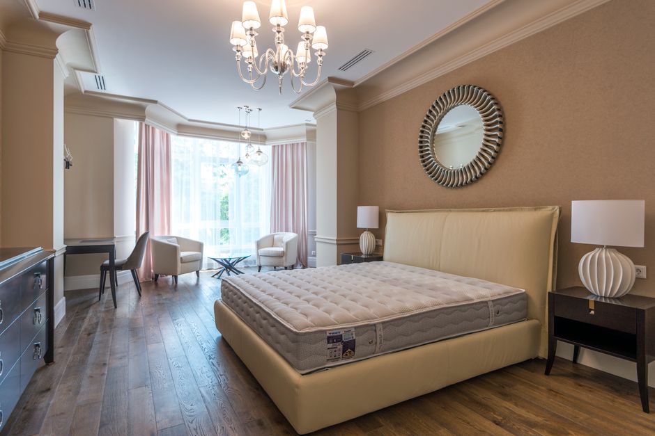Spacious modern bedroom featuring elegant furnishings and abundant natural light.