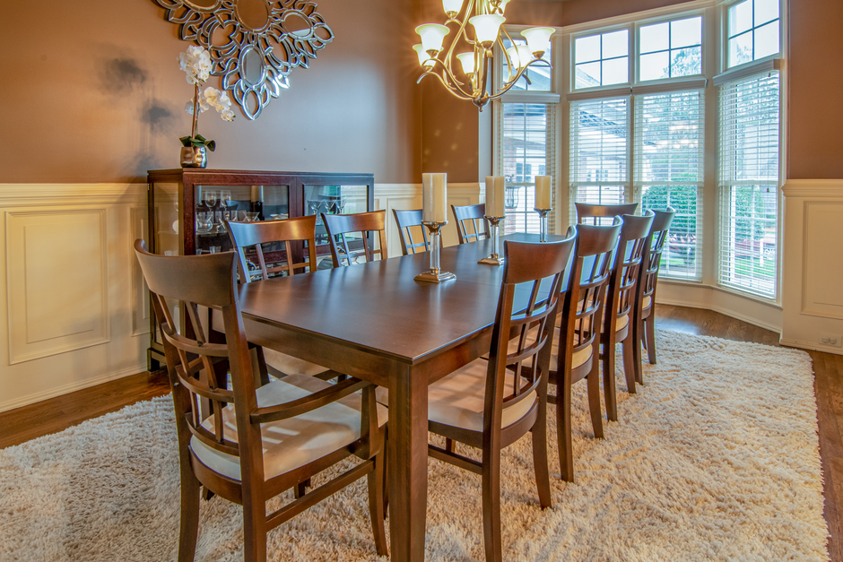 Spacious modern dining room with elegant wooden furniture and natural lighting.