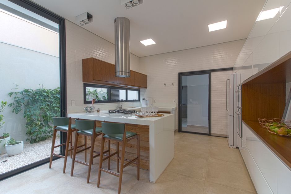 Stylish kitchen featuring white brick walls, wooden decor, and bar stools.