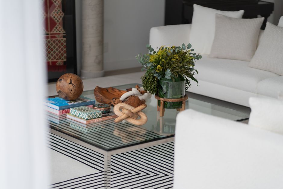 Stylish living room featuring modern decor, a glass coffee table, and green plants.