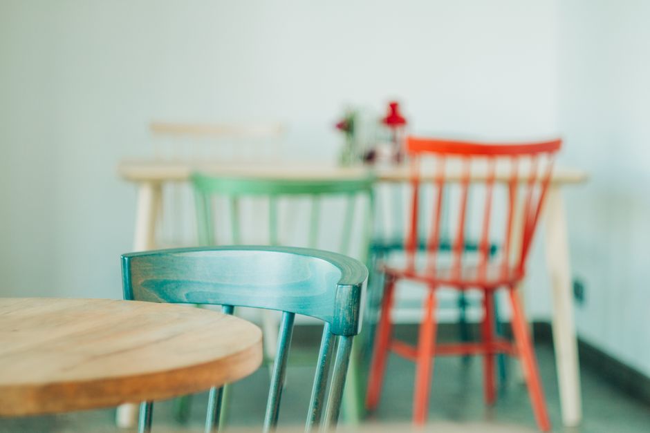 Stylish wooden chairs and table arrangement in a cozy indoor cafe setting.