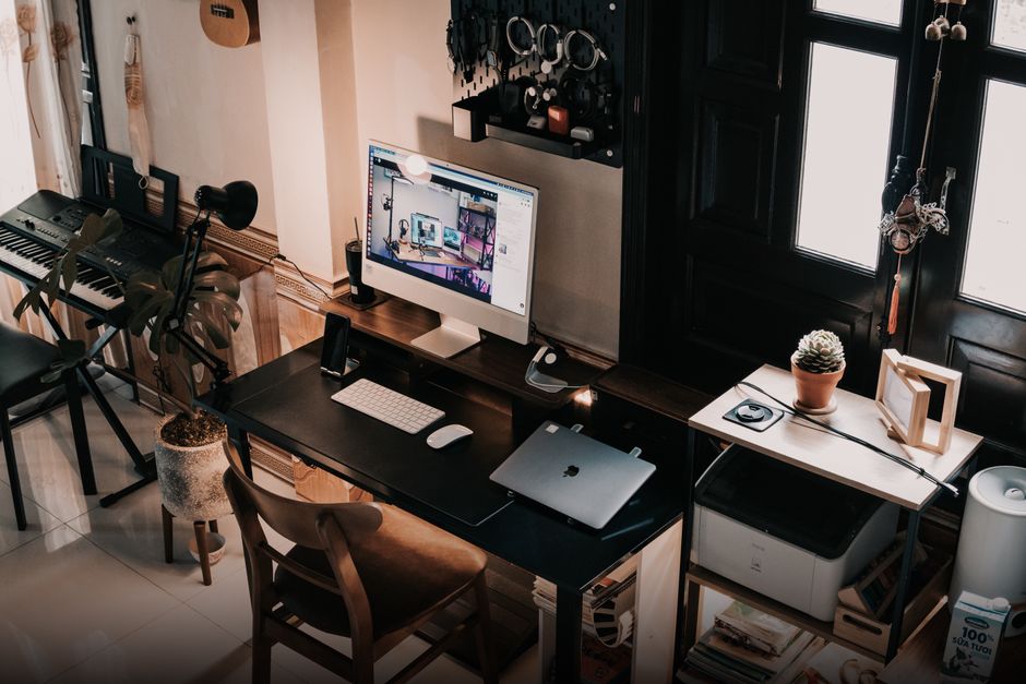 A cozy home office setup featuring a computer desk and musical instruments.