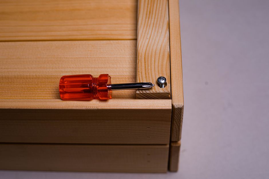 A detailed shot of a screwdriver inserted into a screw on a wooden box. Ideal for DIY themes.