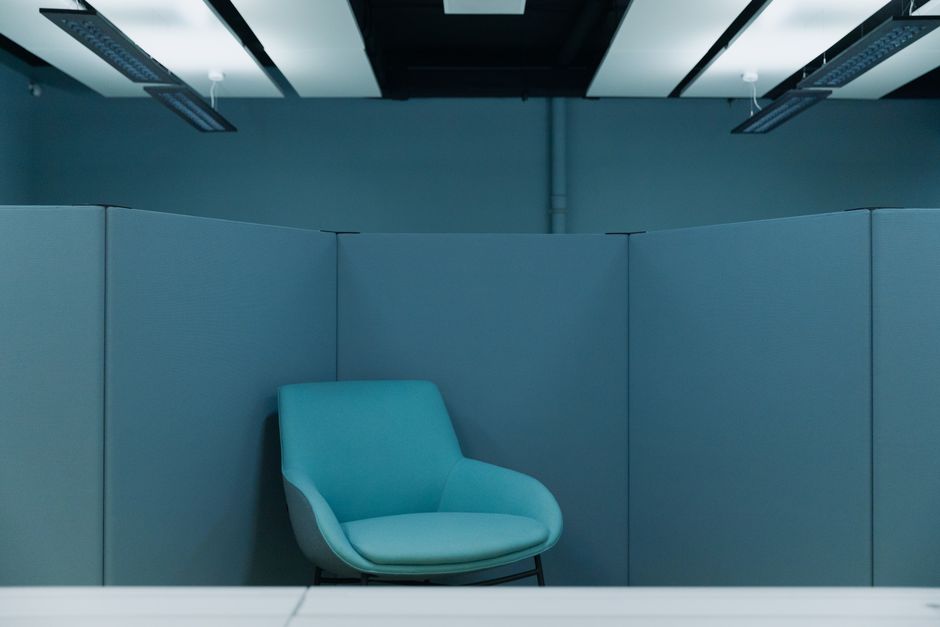 A serene office space featuring a stylish blue chair in a minimalist environment.