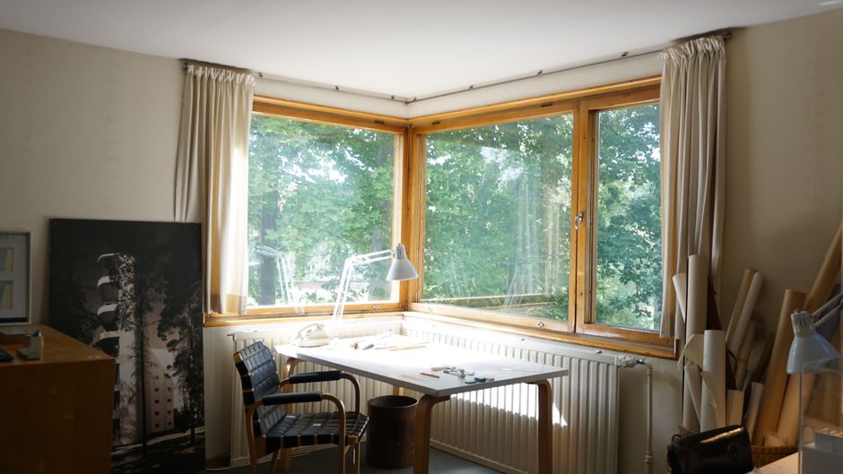 Bright home office with corner windows and minimalist decor, ideal for productivity and inspiration.