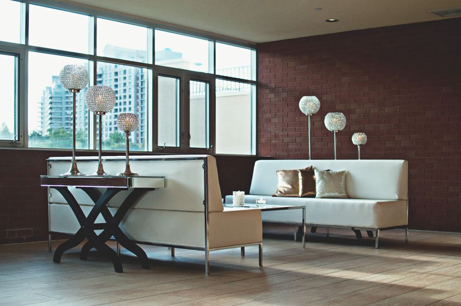Chic living room setup featuring contemporary furniture and crystal lamps against a classic brick wall.