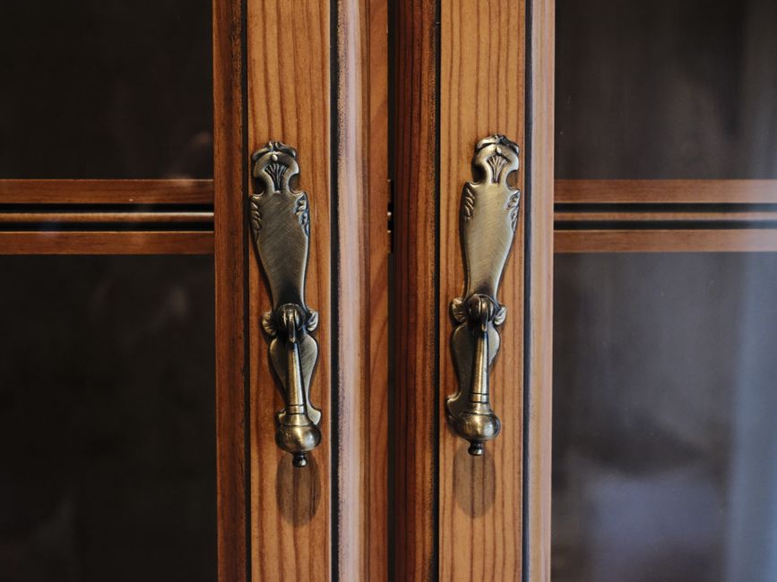 Close-up of elegant brass door handles on a wooden cabinet in Zaragoza, Spain.