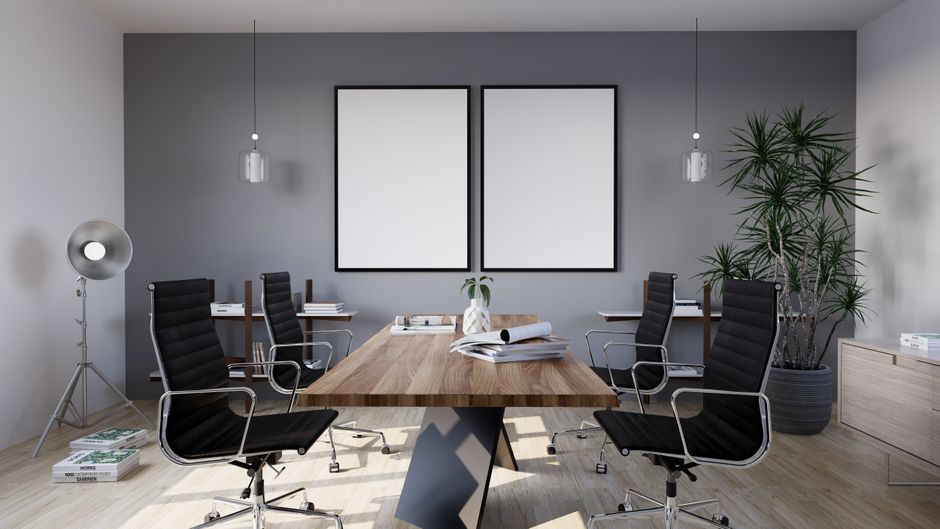 Sleek modern conference room showcasing minimalist design with office chairs, large table, and potted plants.