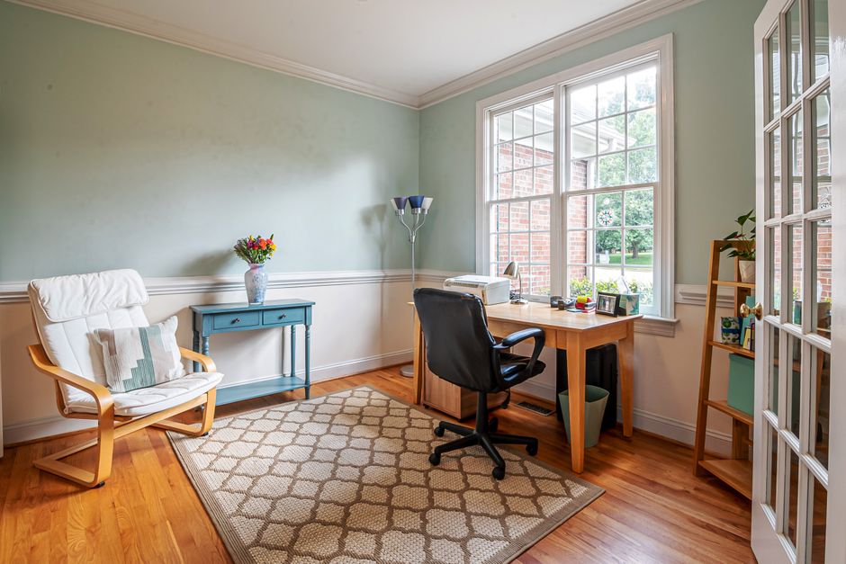 Stylish home office interior with natural light, wooden furniture, and decorative elements.