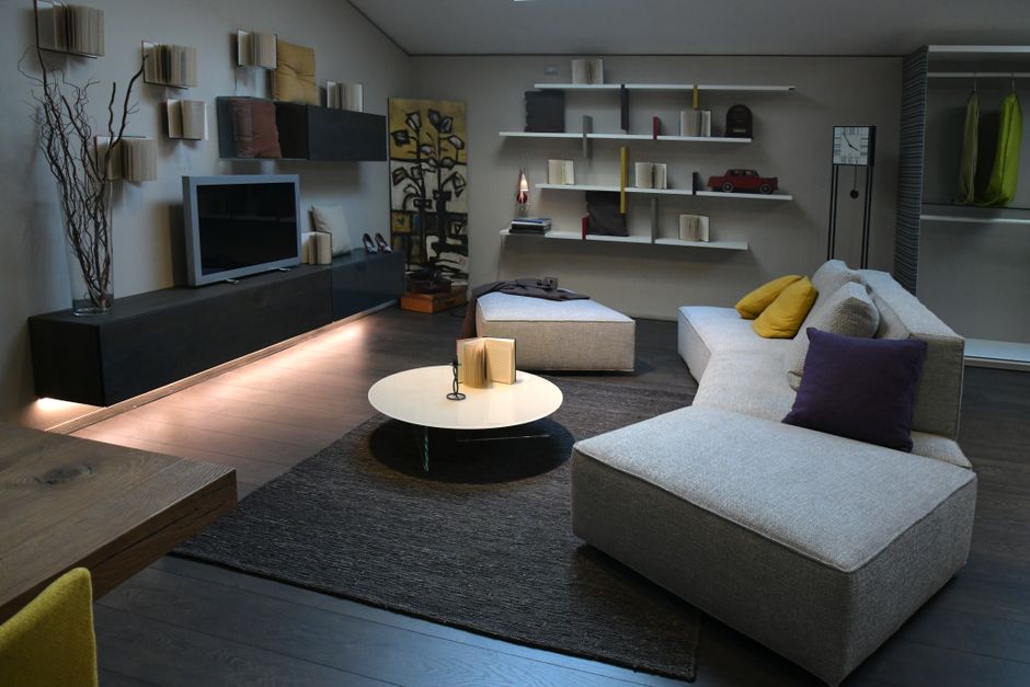 A stylish and cozy living room with modern decor in neutral tones featuring comfortable furniture and creative shelving.