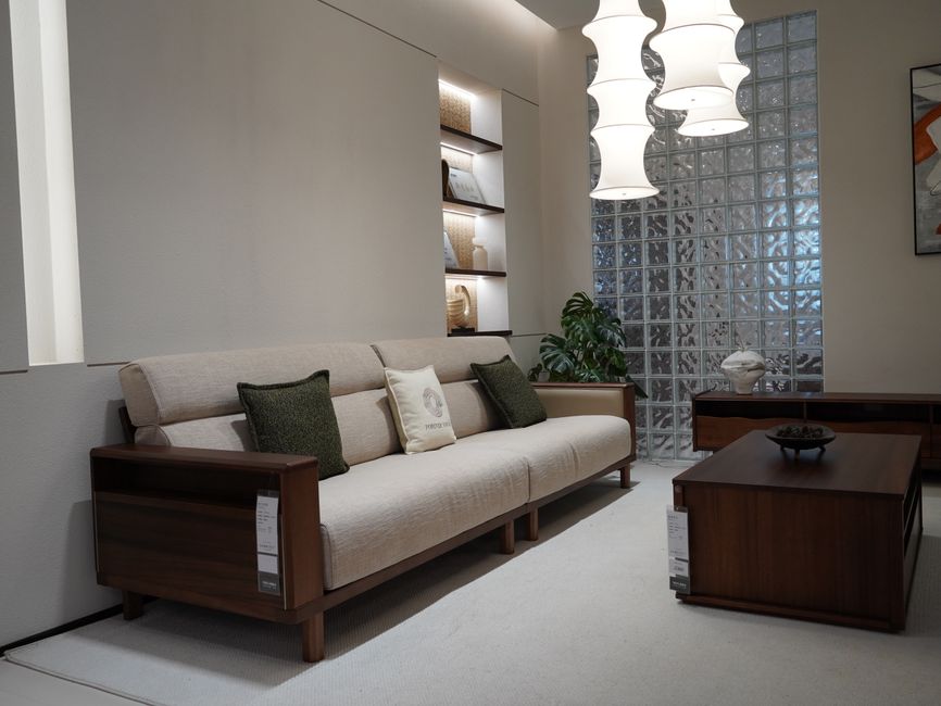 Stylish modern living room with sleek beige sofa, rich wood furniture, and chic decor accents.